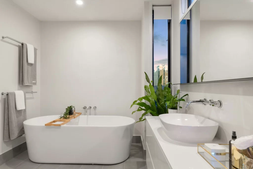 Modern bathroom featuring a large window and a stylish tub, highlighting budget-friendly remodeling options.
